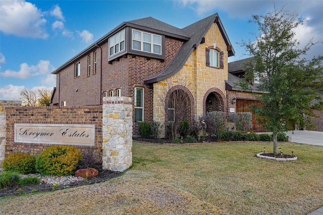 310 Hawthorn Dr, Wylie, TX 75098 - view of front facade with stone siding, roof with shingles, a front yard, and brick siding