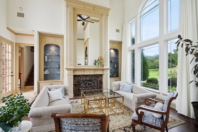 508 Moraine Way, Heath, TX 75032 - living area with a towering ceiling, healthy amount of natural light, a ceiling fan, built in features, and a premium fireplace