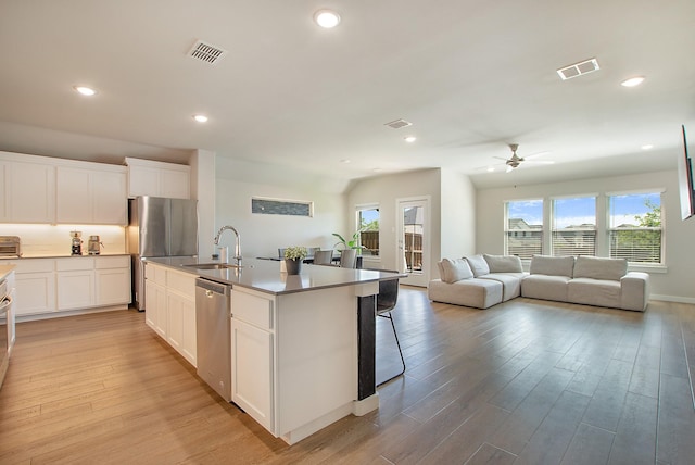4007 Buckeye Bnd, Melissa, TX 75454 - kitchen with appliances with stainless steel finishes, a sink, a ceiling fan, light wood finished floors, and open floor plan