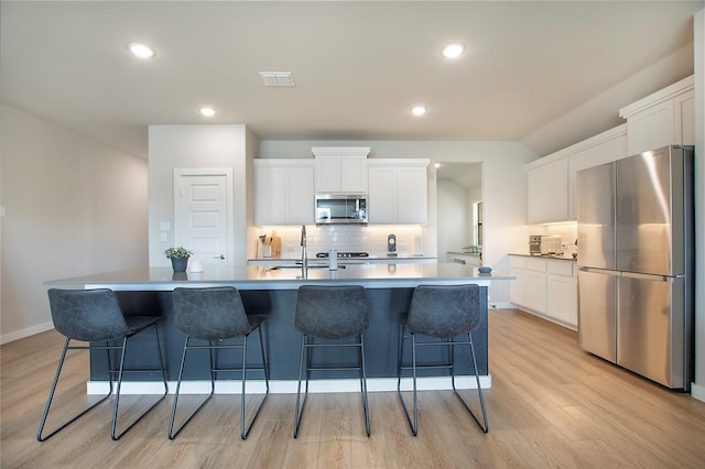 4007 Buckeye Bnd, Melissa, TX 75454 - kitchen featuring appliances with stainless steel finishes, a sink, light wood finished floors, tasteful backsplash, and white cabinets