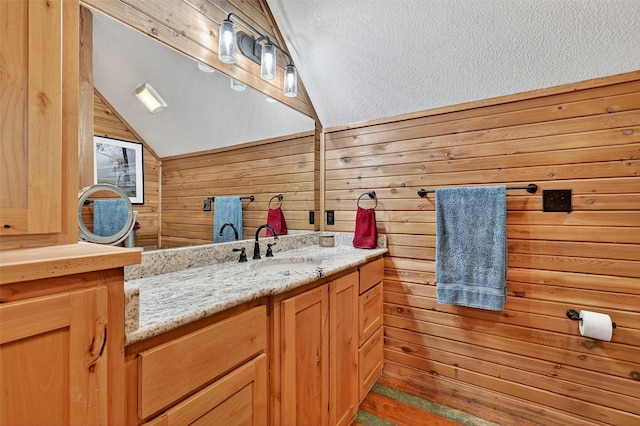 4920 County Road 179, Celina, TX 75009 - bathroom with lofted ceiling, vanity, wooden walls, and a textured ceiling