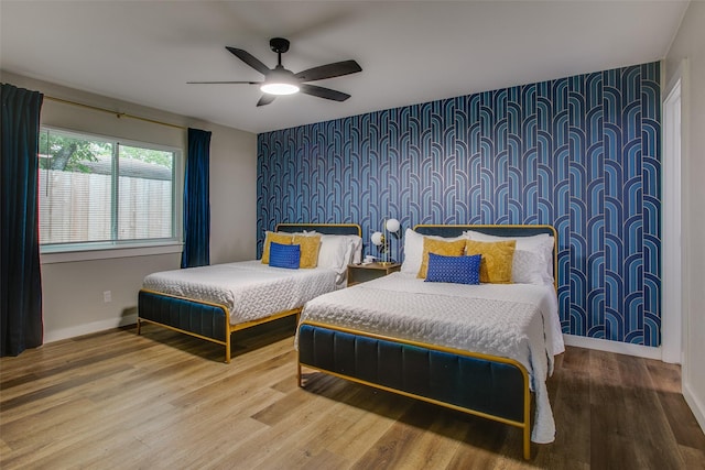 2110 Montana Trl, Grand Prairie, TX 76001 - bedroom featuring an accent wall, wallpapered walls, wood finished floors, baseboards, and ceiling fan