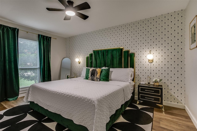 2110 Montana Trl, Grand Prairie, TX 76001 - bedroom featuring wallpapered walls, an accent wall, baseboards, wood finished floors, and ceiling fan