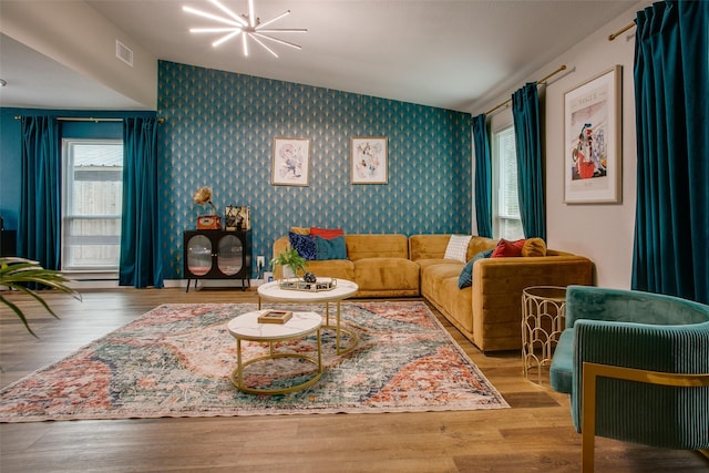 2110 Montana Trl, Grand Prairie, TX 76001 - living room with wallpapered walls, an accent wall, a chandelier, vaulted ceiling, and wood finished floors