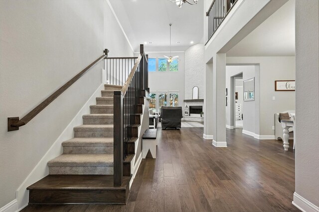 7431 Bald Cypress Dr, Ovilla, TX 75154 - dining space featuring stairway, a chandelier, dark wood-style flooring, and a towering ceiling