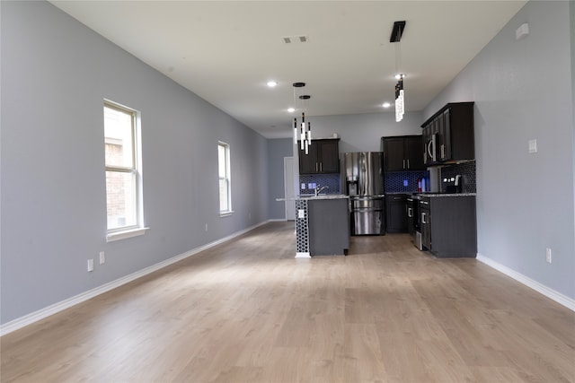 1610 Seadrift Dr, Forney, TX 75126 - kitchen featuring appliances with stainless steel finishes, a kitchen island with sink, tasteful backsplash, open floor plan, and hanging light fixtures