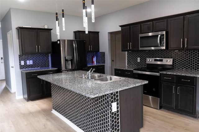 1610 Seadrift Dr, Forney, TX 75126 - kitchen featuring stainless steel appliances, light wood-style flooring, backsplash, a kitchen island with sink, and decorative light fixtures