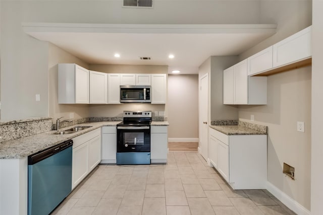 3301 Cliffview Dr, Corinth, TX 76210 - kitchen with stainless steel appliances, a sink, white cabinetry, light stone counters, and recessed lighting
