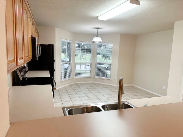 9404 Mirror Fountain Cir, Frisco, TX 75033 - kitchen with stainless steel range with electric stovetop, a sink, light countertops, pendant lighting, and freestanding refrigerator