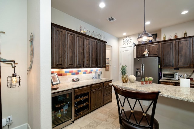 5100 Swisher Rd, Denton, TX 76208 - kitchen with stainless steel fridge, wine cooler, backsplash, dark brown cabinetry, and light stone counters