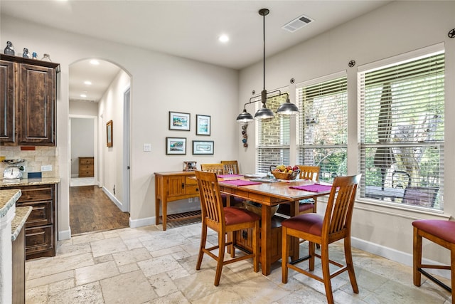 5100 Swisher Rd, Denton, TX 76208 - dining area featuring arched walkways, baseboards, stone tile flooring, and recessed lighting