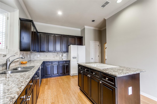 3704 Roxbury Ln, Plano, TX 75025 - kitchen with white appliances, a center island, light wood-style floors, light stone countertops, and crown molding