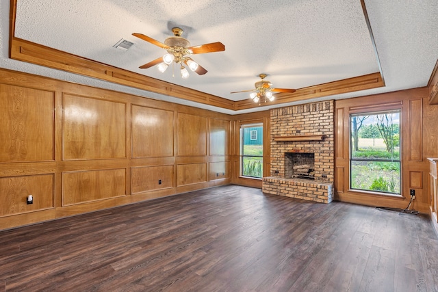 3837 Fm 896th 2, Leonard, TX 75452 - unfurnished living room featuring a textured ceiling, a tray ceiling, a ceiling fan, a fireplace, and dark wood-style flooring
