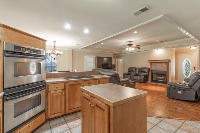 10763 Nix Ln, Whitehouse, TX 75791 - kitchen featuring stainless steel double oven, a fireplace, crown molding, a chandelier, and open floor plan