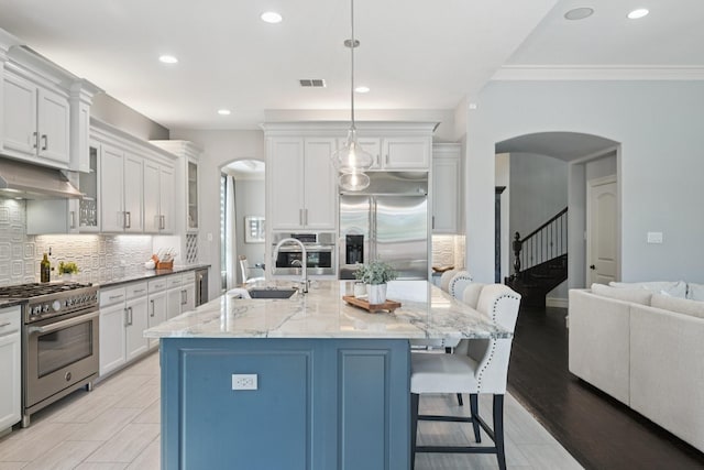 4158 Benchmark Ln, Frisco, TX 75034 - kitchen with high quality appliances, arched walkways, tasteful backsplash, a sink, and white cabinets