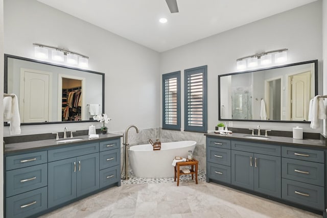 4158 Benchmark Ln, Frisco, TX 75034 - bathroom featuring two vanities, a freestanding bath, a ceiling fan, and a walk in closet