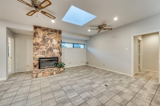 2308 Aberdeen Bnd, Carrollton, TX 75007 - unfurnished living room with a ceiling fan, a fireplace, a skylight, light tile patterned floors, and recessed lighting