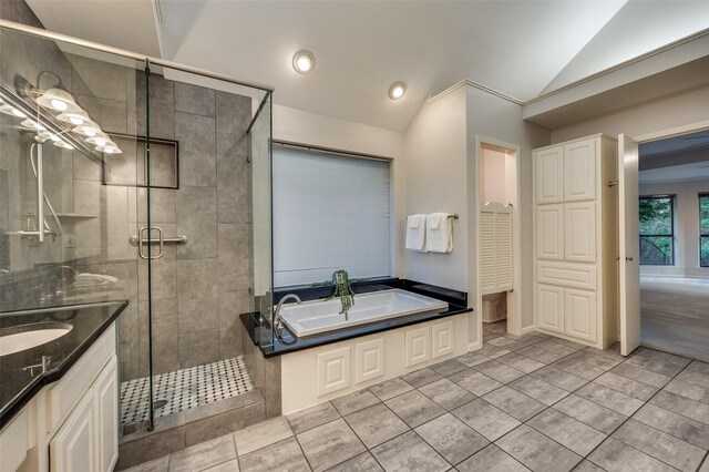 2308 Aberdeen Bnd, Carrollton, TX 75007 - bathroom with vaulted ceiling, a garden tub, vanity, a shower stall, and tile patterned floors