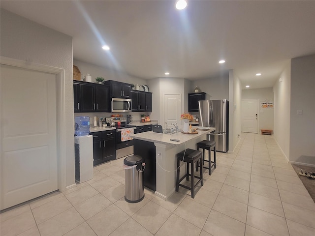 3400 Quiet Valley Rd, Fort Worth, TX 76123 - kitchen featuring appliances with stainless steel finishes, dark cabinetry, light countertops, a breakfast bar, and a sink