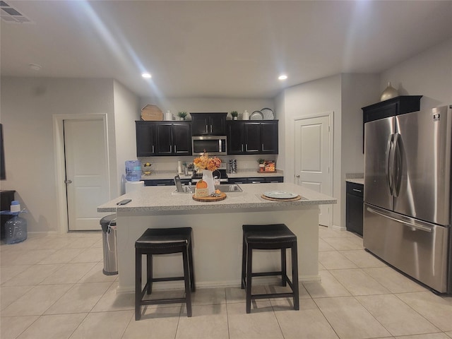 3400 Quiet Valley Rd, Fort Worth, TX 76123 - kitchen with stainless steel appliances, dark cabinetry, a breakfast bar, light tile patterned floors, and recessed lighting