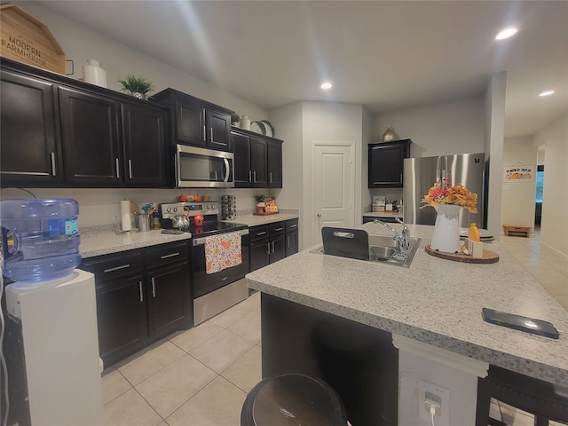 3400 Quiet Valley Rd, Fort Worth, TX 76123 - kitchen featuring stainless steel appliances, a sink, dark cabinetry, light tile patterned floors, and recessed lighting