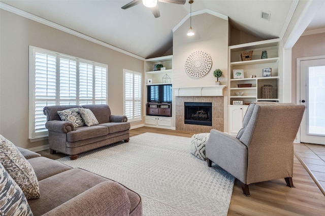 1908 Thompson Ct, Flower Mound, TX 75028 - living room with ornamental molding, healthy amount of natural light, a tile fireplace, built in shelves, and a ceiling fan