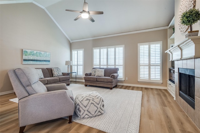 1908 Thompson Ct, Flower Mound, TX 75028 - living area featuring a tiled fireplace, light wood-type flooring, a ceiling fan, plenty of natural light, and ornamental molding
