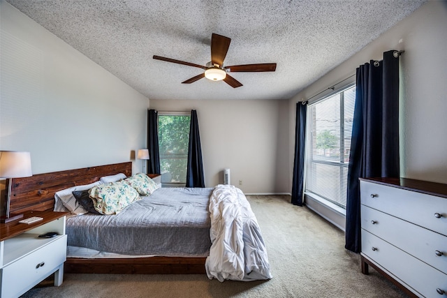 12834 Midway Rd Unit 1105, Dallas, TX 75244 - bedroom featuring multiple windows, carpet floors, a textured ceiling, and ceiling fan