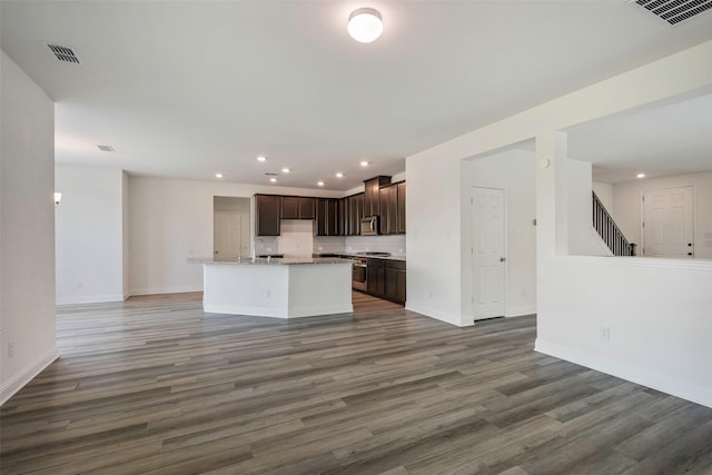 4224 Wood River Trl, Prosper, TX 75078 - kitchen with open floor plan, dark brown cabinetry, wood finished floors, recessed lighting, and an island with sink