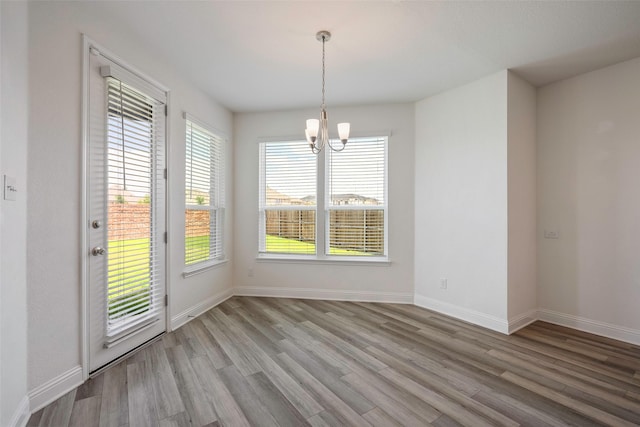 4224 Wood River Trl, Prosper, TX 75078 - unfurnished dining area with a chandelier, wood finished floors, and baseboards