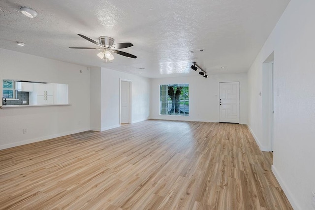 6509 S Hulen St, Fort Worth, TX 76133 - unfurnished living room featuring light wood-style flooring, a ceiling fan, a textured ceiling, and baseboards