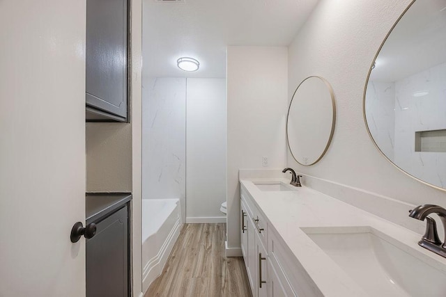 6509 S Hulen St, Fort Worth, TX 76133 - bathroom featuring wood finished floors, double vanity, toilet, and shower / washtub combination