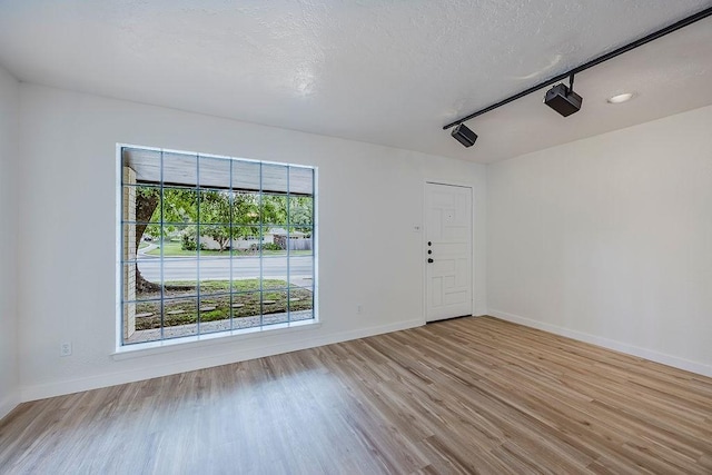 6509 S Hulen St, Fort Worth, TX 76133 - unfurnished room featuring wood finished floors, baseboards, and a textured ceiling