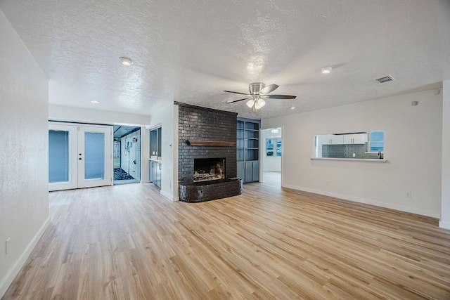 6509 S Hulen St, Fort Worth, TX 76133 - unfurnished living room with baseboards, light wood-style floors, a ceiling fan, a textured ceiling, and french doors