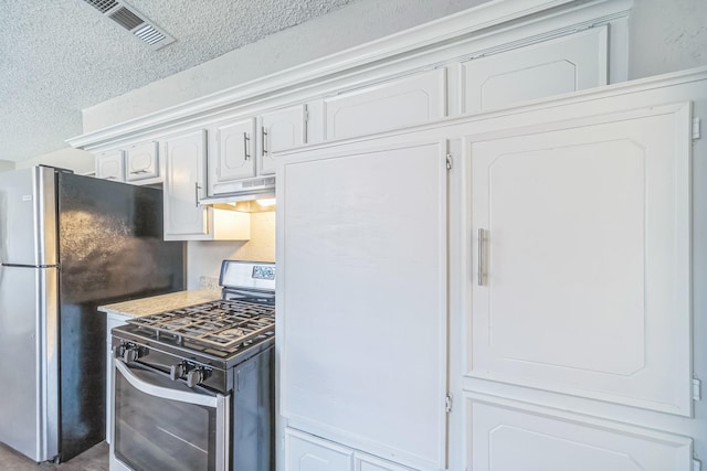 715 San Juan Dr, Duncanville, TX 75116 - kitchen with stainless steel appliances, a textured ceiling, white cabinetry, light countertops, and under cabinet range hood