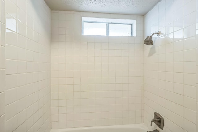 715 San Juan Dr, Duncanville, TX 75116 - bathroom featuring a textured ceiling and tub / shower combination