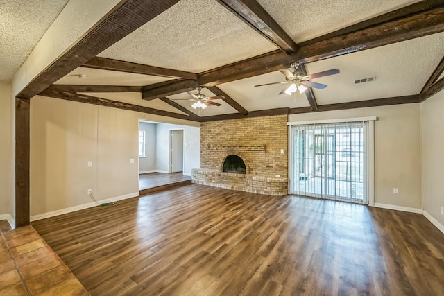 715 San Juan Dr, Duncanville, TX 75116 - unfurnished living room with a textured ceiling, dark wood-style flooring, a ceiling fan, beamed ceiling, and baseboards