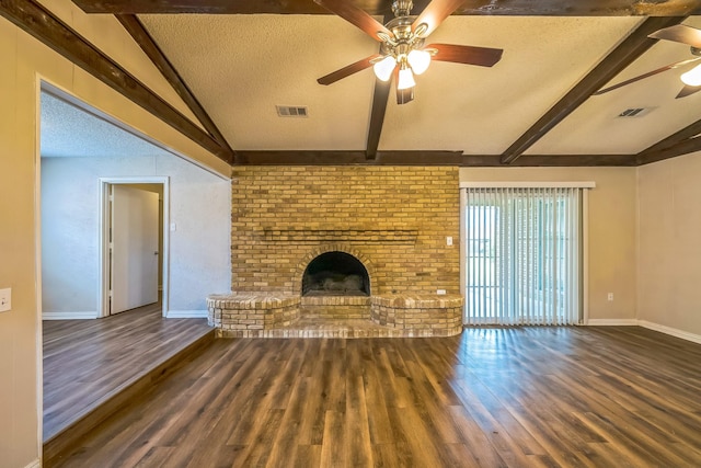 715 San Juan Dr, Duncanville, TX 75116 - unfurnished living room featuring ceiling fan, a textured ceiling, a brick fireplace, wood finished floors, and baseboards