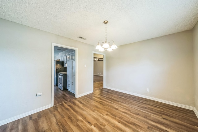 715 San Juan Dr, Duncanville, TX 75116 - unfurnished dining area featuring a chandelier, dark wood-type flooring, baseboards, and a textured ceiling