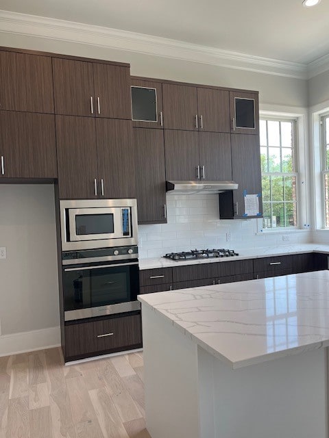 5024 Magnolia Cir, Addison, TX 75001 - kitchen featuring stainless steel appliances, backsplash, ornamental molding, dark brown cabinets, and light stone counters