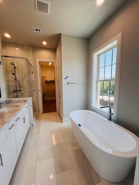 5024 Magnolia Cir, Addison, TX 75001 - full bath with a stall shower, vanity, a walk in closet, a freestanding bath, and recessed lighting
