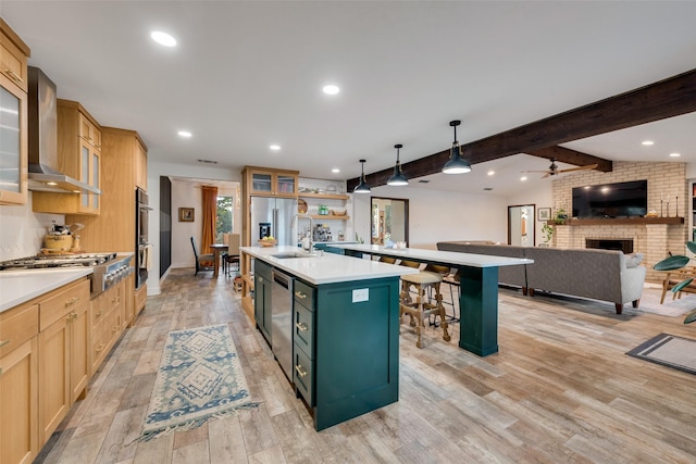 8608 Funtier Ct, Fort Worth, TX 76179 - kitchen with wall chimney exhaust hood, an island with sink, appliances with stainless steel finishes, light countertops, and a brick fireplace
