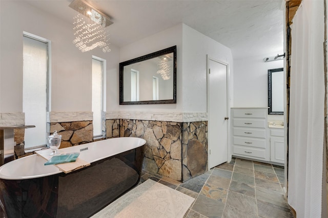 8608 Funtier Ct, Fort Worth, TX 76179 - full bath featuring stone tile flooring, a freestanding tub, and wainscoting