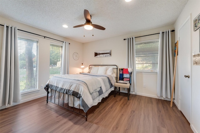 8608 Funtier Ct, Fort Worth, TX 76179 - bedroom with wood finished floors, a textured ceiling, baseboards, a ceiling fan, and recessed lighting