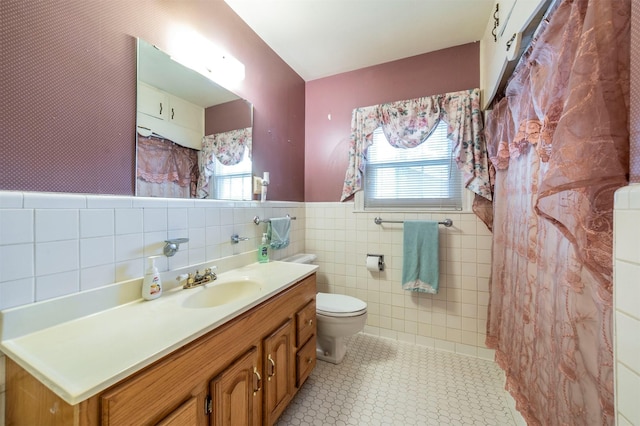 612 W Simmons St, Weatherford, TX 76086 - full bath featuring toilet, vanity, tile walls, wainscoting, and a shower with curtain