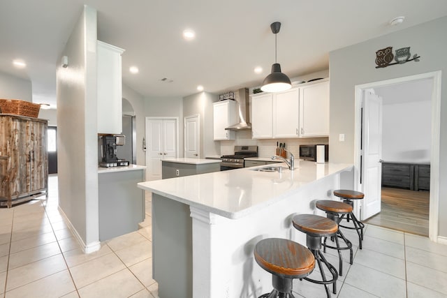 5604 Durst Ln, Forney, TX 75126 - kitchen with stainless steel gas stove, wall chimney range hood, a sink, light tile patterned floors, and decorative backsplash