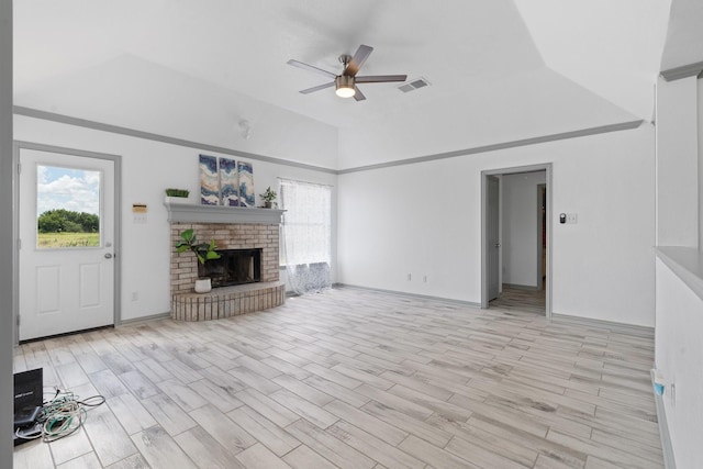 2600 Dave Angel Rd, Burleson, TX 76028 - unfurnished living room with a ceiling fan, vaulted ceiling, a brick fireplace, and light wood-style flooring