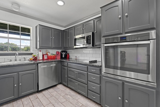 2600 Dave Angel Rd, Burleson, TX 76028 - kitchen with stainless steel appliances, gray cabinetry, tasteful backsplash, and dark stone counters
