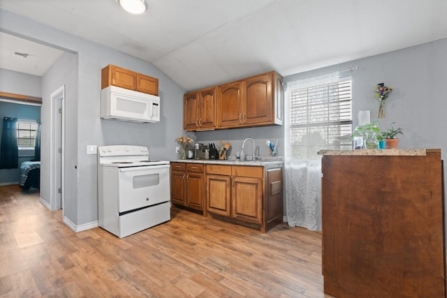 2600 Dave Angel Rd, Burleson, TX 76028 - kitchen featuring white appliances, brown cabinets, light countertops, light wood-style floors, and lofted ceiling