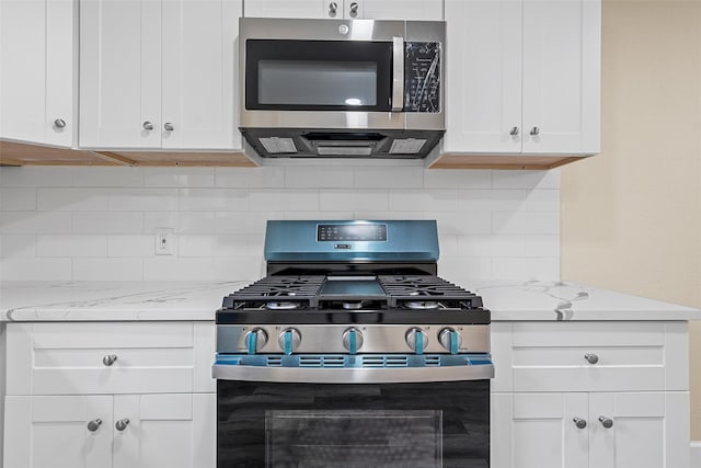 1024 N 45th St, Waco, TX 76710 - kitchen with stainless steel appliances, white cabinets, backsplash, and light stone counters